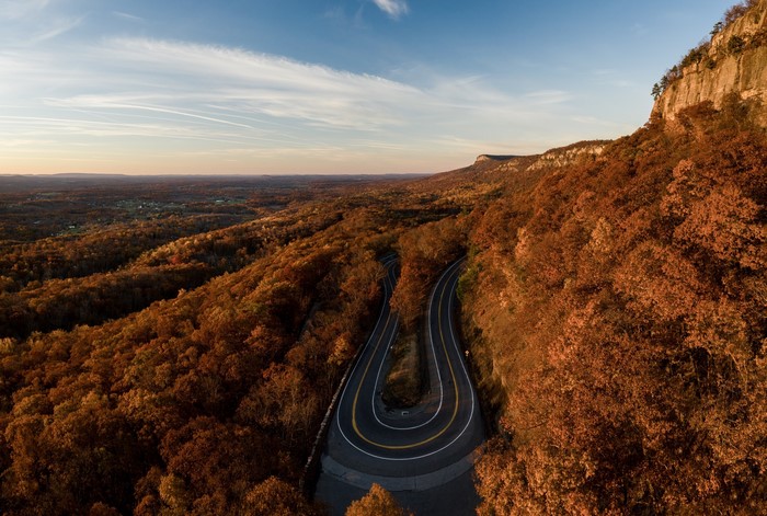 Winding mountain road through autumn forest