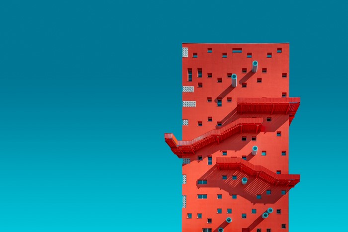 Red building with external stairs against a blue sky