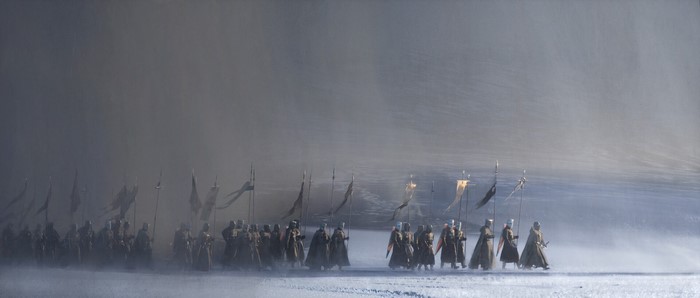 Medieval crusaders with banners in a foggy landscape