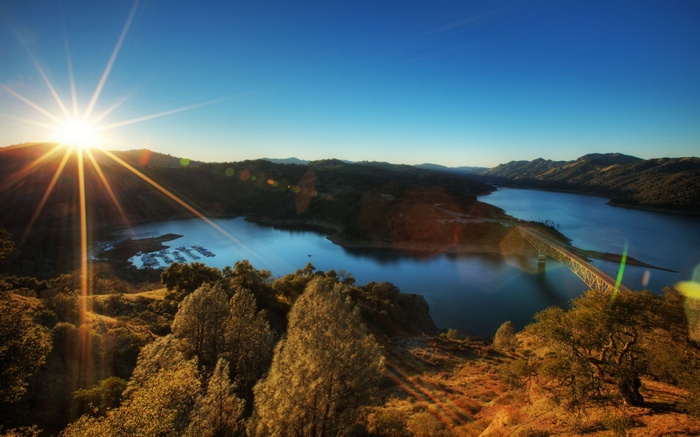 Sunrise over a lake with a bridge and marina