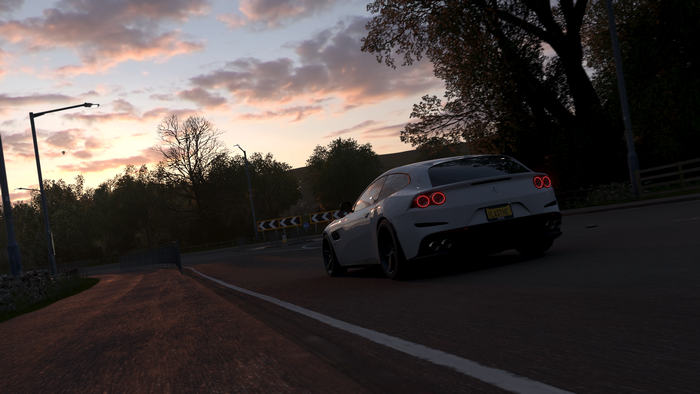 White Ferrari GTC4Lusso driving on road during sunset