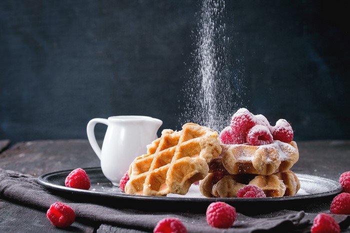 Waffles with raspberries and powdered sugar