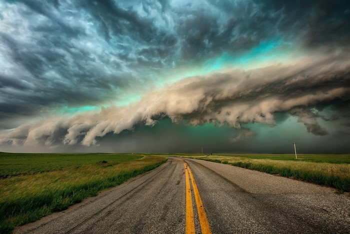 Stormy sky over a road in a green landscape