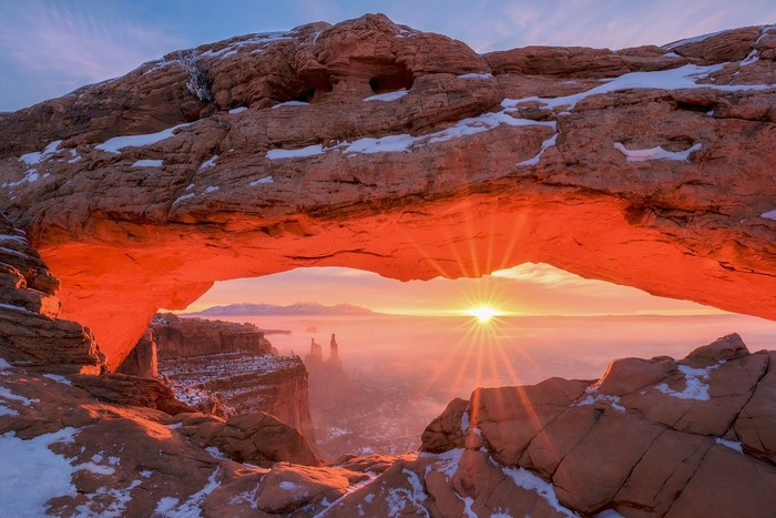 Sunrise through Mesa Arch with snow