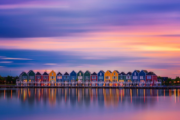 Colorful houses reflected in water at sunset