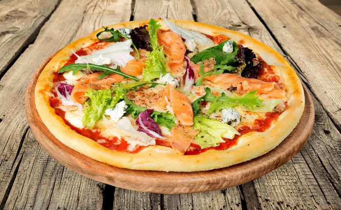 Pizza with salmon, cheese, and salad