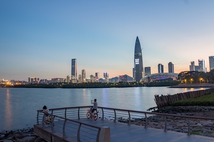 Shenzhen cityscape with skyscrapers and a waterfront promenade at dusk