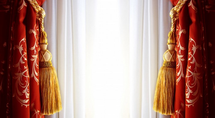 Red and gold curtains with white sheer drapes