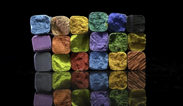 Colorful chalk sticks arranged in rows on a black surface