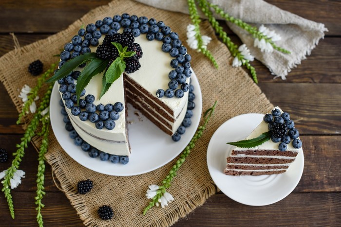Chocolate layer cake with white frosting, blueberries, and blackberries
