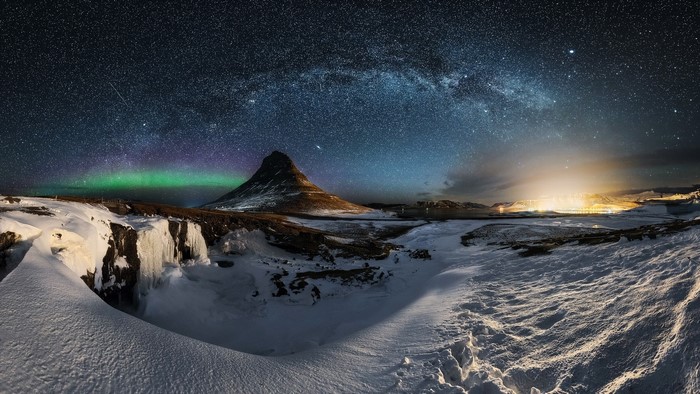 Kirkjufell mountain under the Milky Way and Aurora Borealis