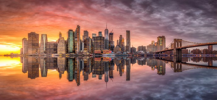 New York City skyline and Brooklyn Bridge at sunset reflection