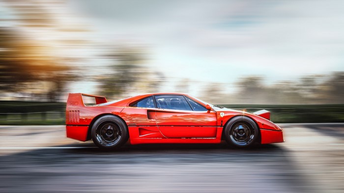 Red Ferrari F40 driving on asphalt