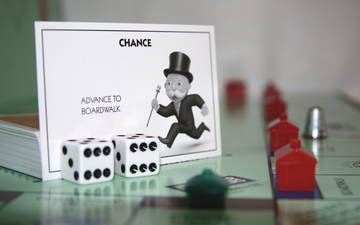 Monopoly Chance card with dice and game pieces