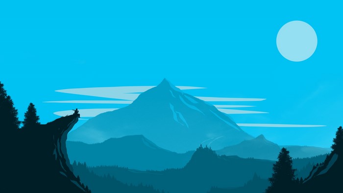 Man sitting on a cliff overlooking mountains