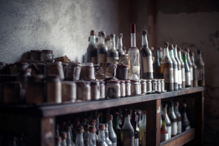 Old bottles and jars on dusty shelves