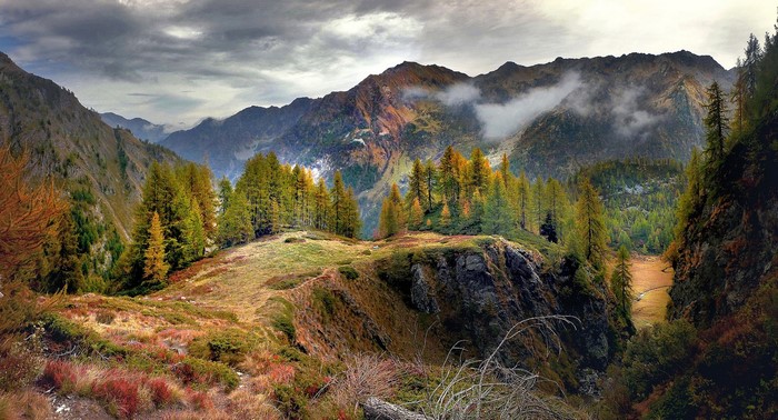 Autumn mountain landscape with trees and clouds