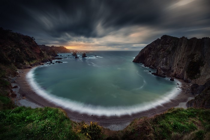 Long exposure of a rocky coast and sea under a cloudy sky