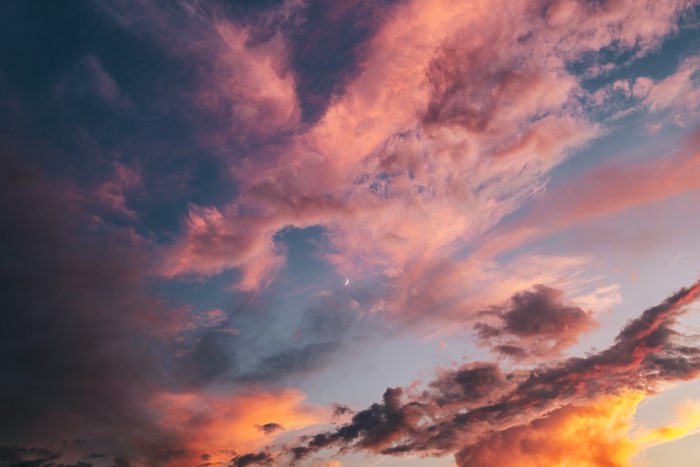 Colorful sunset clouds with a crescent moon