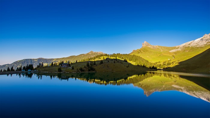 Mountain lake with reflection and clear blue sky