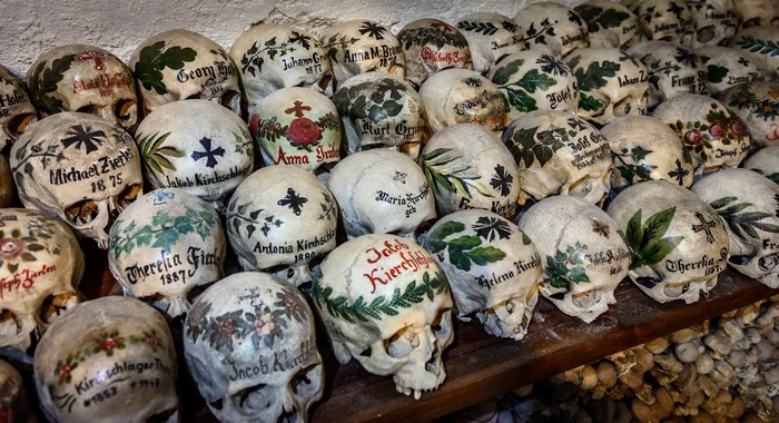 Painted skulls with names and dates in a bone church