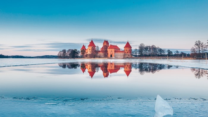 Trakai Island Castle reflected in a frozen lake in winter