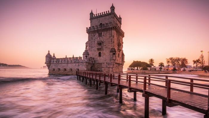 Torre de Belém castle tower at sunrise with wooden walkway