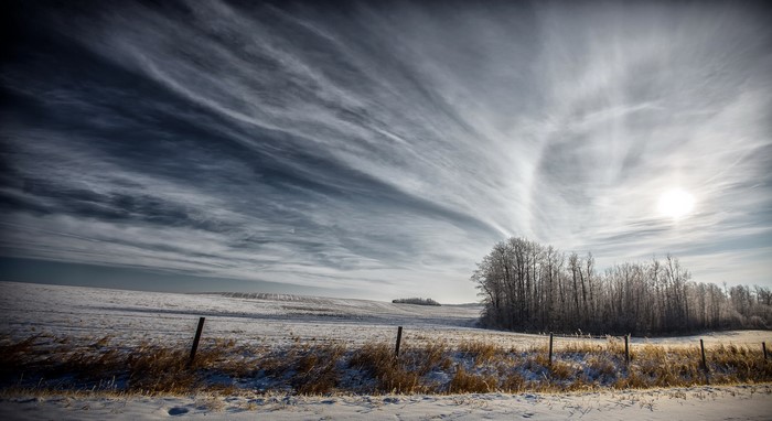Winter landscape with snow-covered fields and dramatic clouds