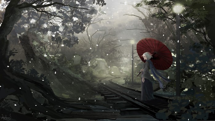 Girl with umbrella on train tracks in snow