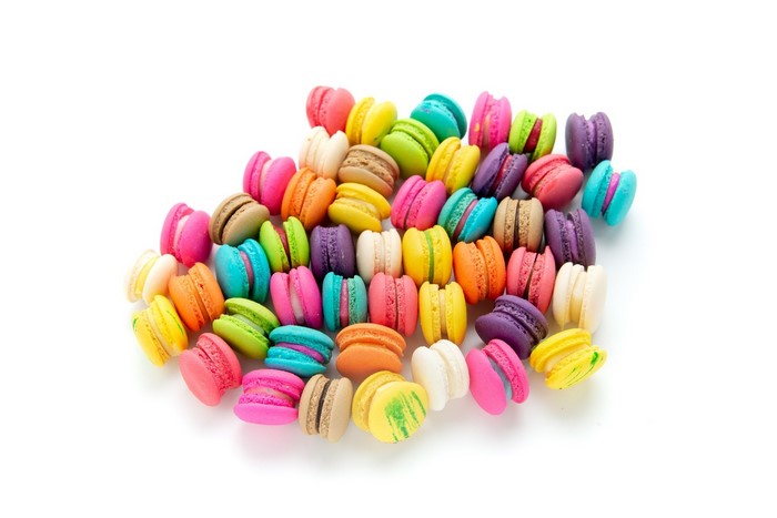 A pile of colorful macarons on a white background