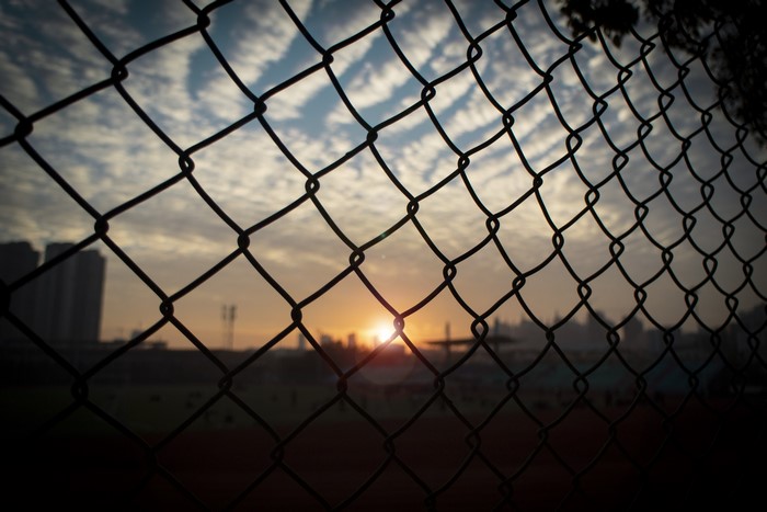 Sunset behind a chain-link fence