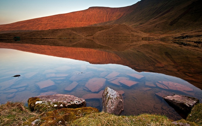 Lake reflecting a mountain at sunset