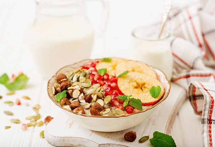 Oatmeal with nuts, seeds, pomegranate, and apple slices