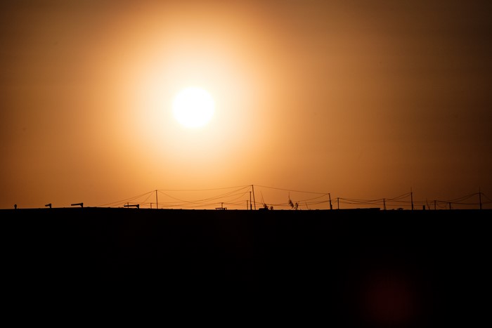 Sunset over rooftops with power lines