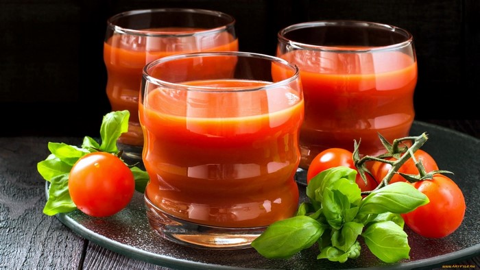 Three glasses of tomato juice with tomatoes and basil