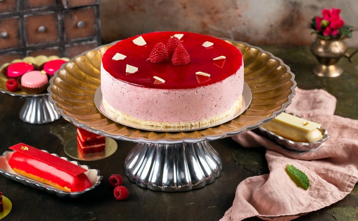 Raspberry mousse cake with fresh raspberries and eclairs
