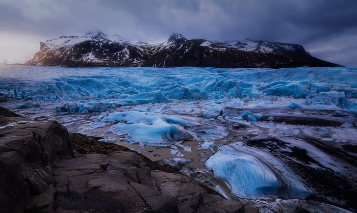 Blue glacier with snow-capped mountains in Iceland