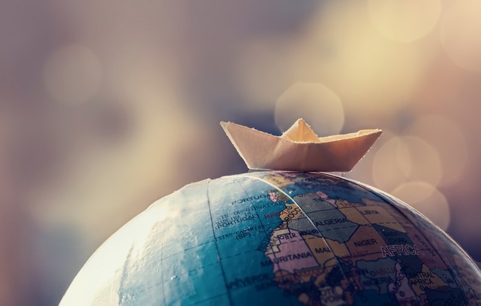Paper boat on a globe