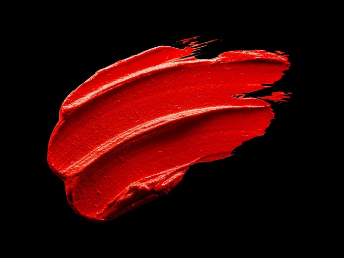 Red lipstick smear on black background