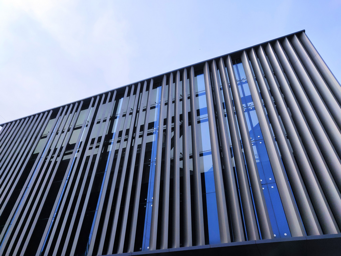 Modern building facade with vertical metal louvers and glass windows