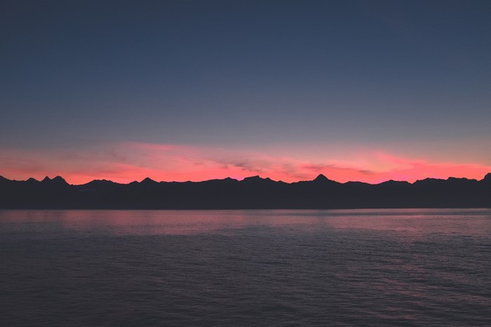 Silhouette of mountains over the sea at sunset