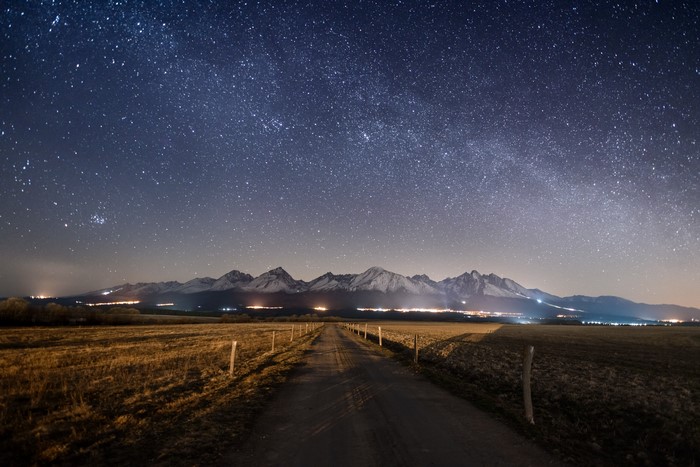Starry night over mountains and a road
