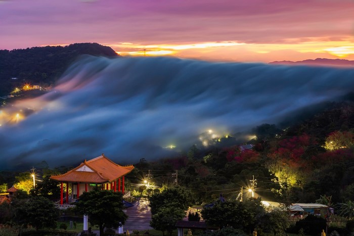 Temple in mist with colorful sky at dusk