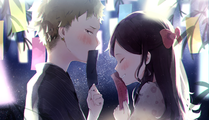 Couple holding tanzaku at a festival at night