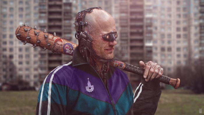 Cyborg man with baseball bat in front of buildings