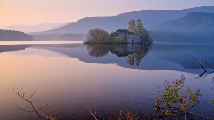 Castle ruins on an island in a lake at sunrise