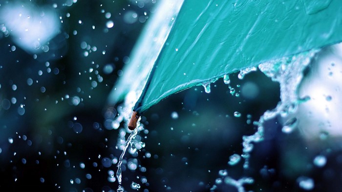 Close-up of a teal umbrella in the rain