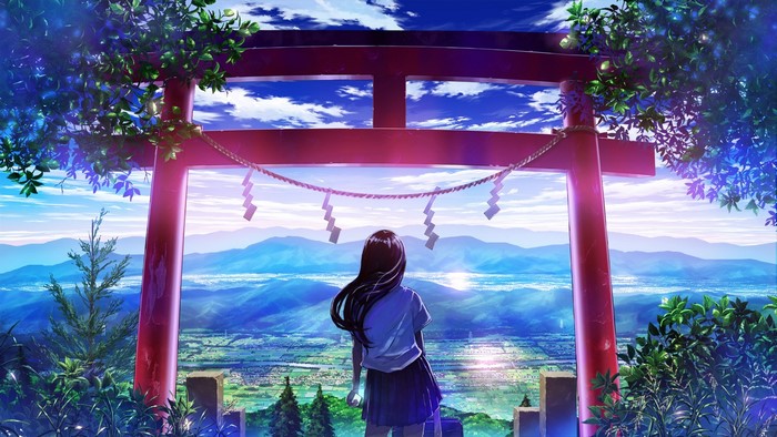 Girl in front of Torii gate overlooking a valley