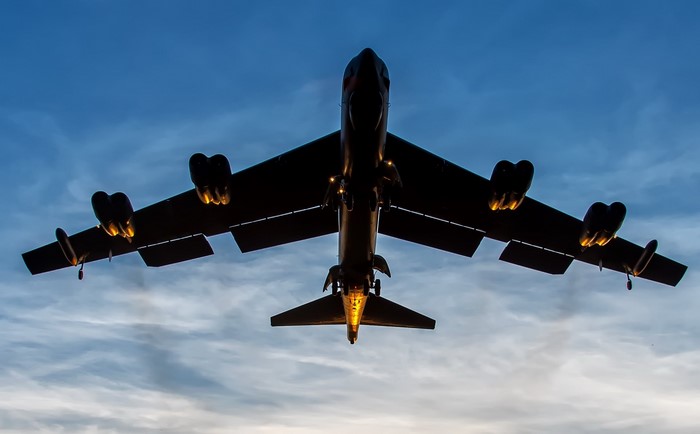 Boeing B-52 Stratofortress bomber flying at dusk