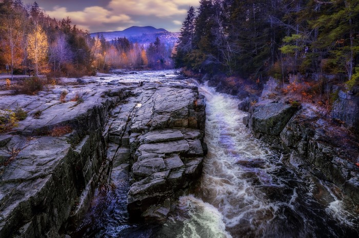 River flowing through rocky gorge with autumn trees
